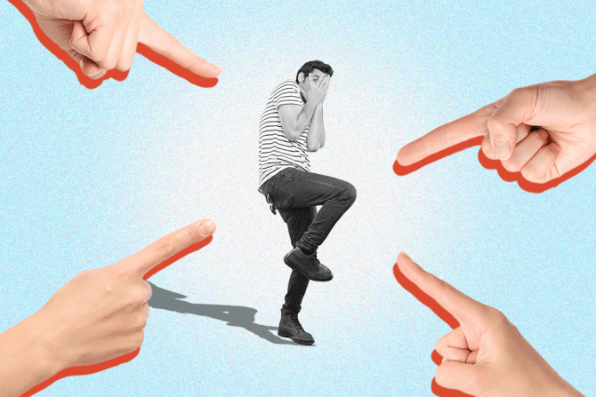 Fingers pointing at a man looking scared with his hands over his face to represent criticism