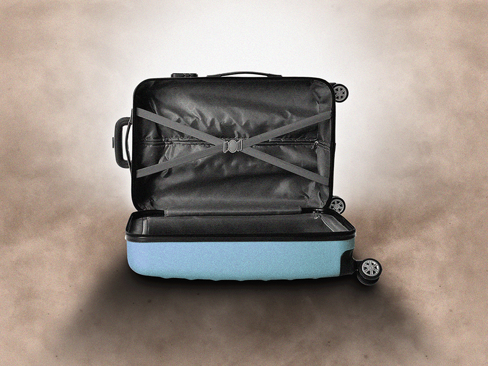 An empty suitcase under a dramatic drop shadow to symbolize post-vacation depression