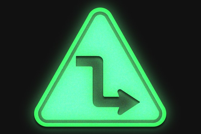 green road sign showing a sharp turn