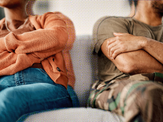 a couple on a couch with their arms crossed because one has an insecure attachment style
