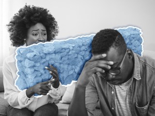 a woman talking to a man with a stone wall between them