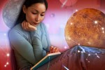 A woman reading with planets in the background