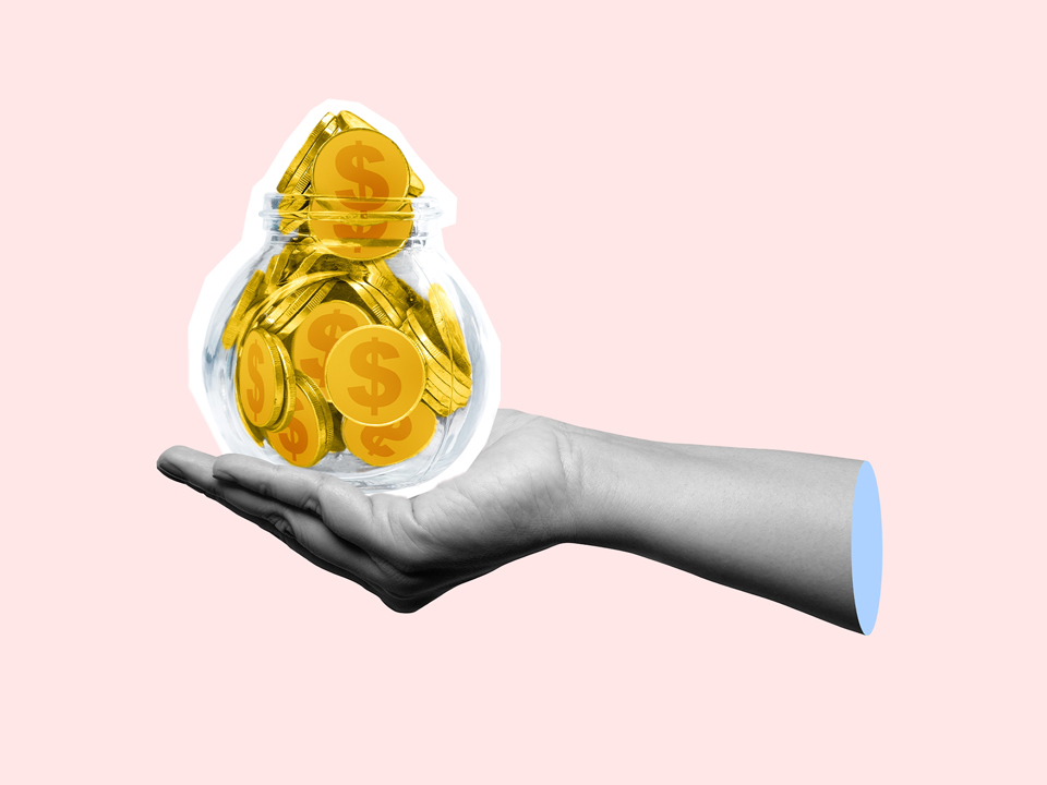 A hand holding a jar of cash. This person may need to see a financial therapist